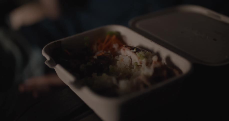 Person eating chinese food with chopsticks out of a container