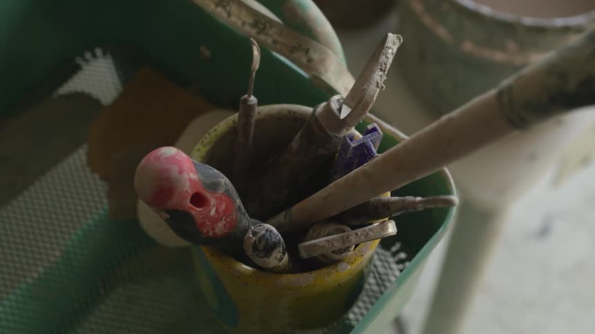 A person removes a tool from a bucket