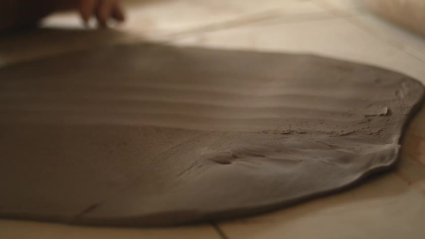 Scraper being used to scrape a thin layer of clay