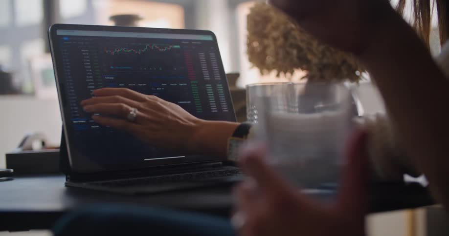 Coworkers discuss data and graph on laptop screen