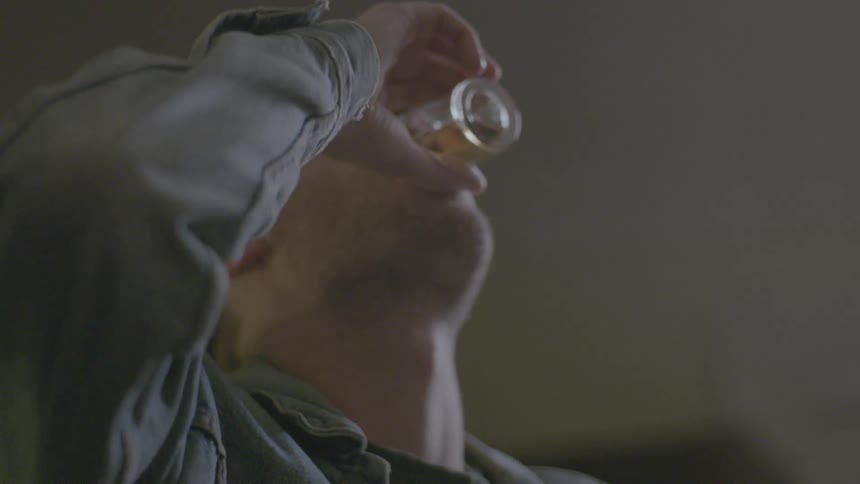 A man takes a drink from a glass