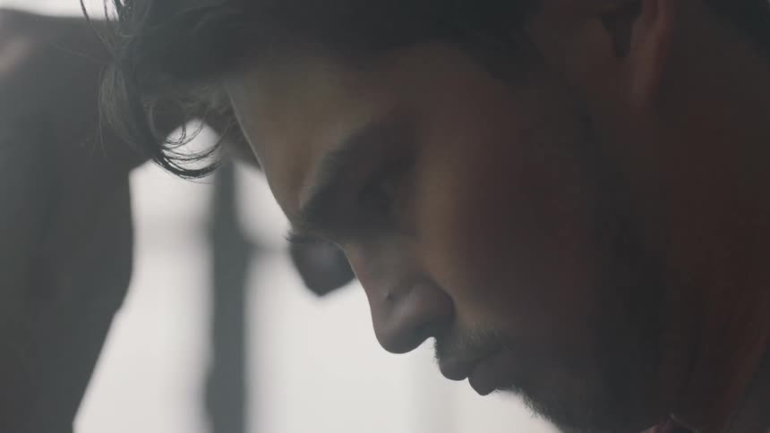 A man concentrates while he works with a piece of wood