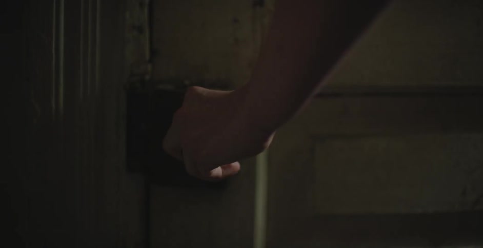 Person approaching and touching a doorknob