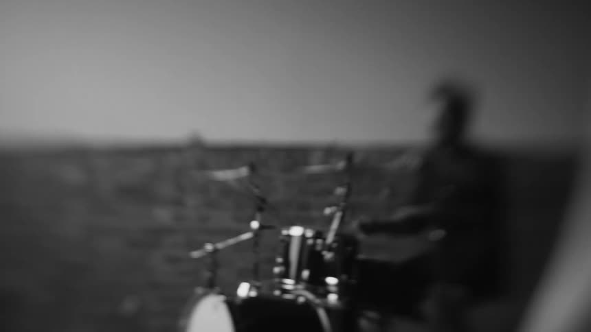 A man is playing drums outside