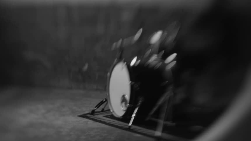 Male drummer plays a drumkit in black and white