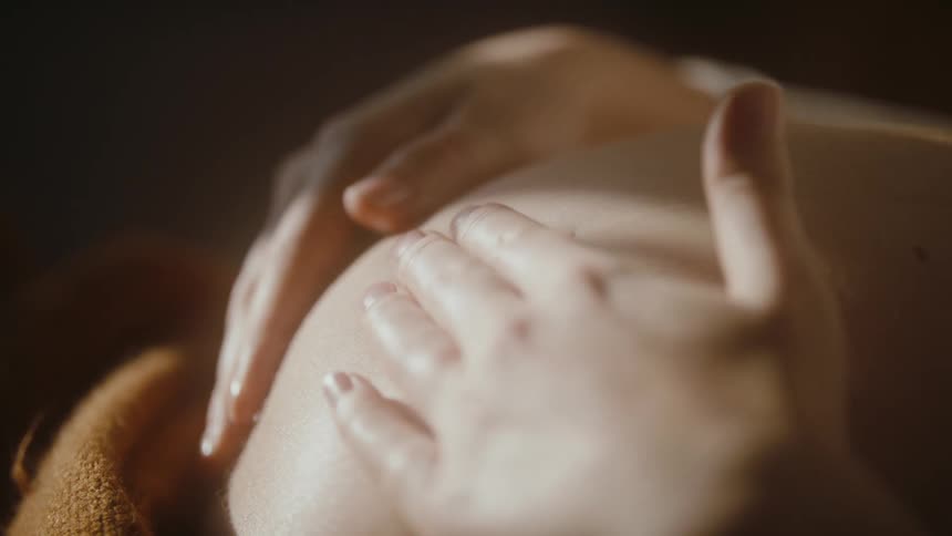 A pregnant woman rubs her belly