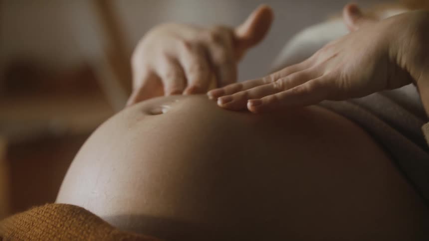 A pregnant woman laying in a bed