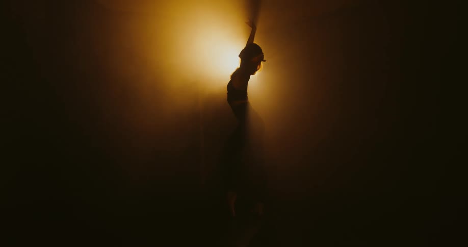 A person is performing ballet under the light
