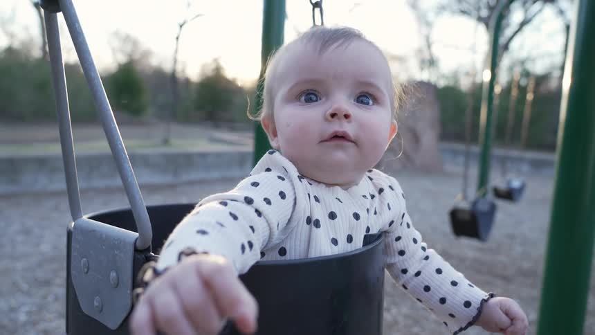A view of a child on a swing in a park