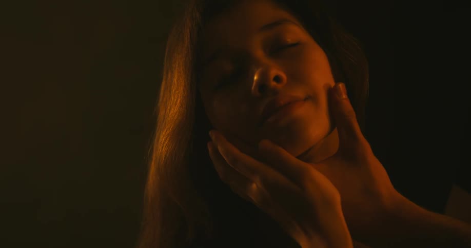 A man grabs a womans face
