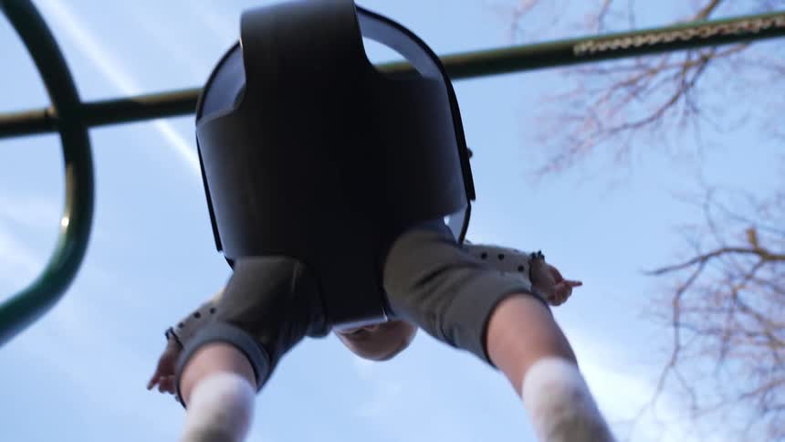 A baby is swinging on the tree