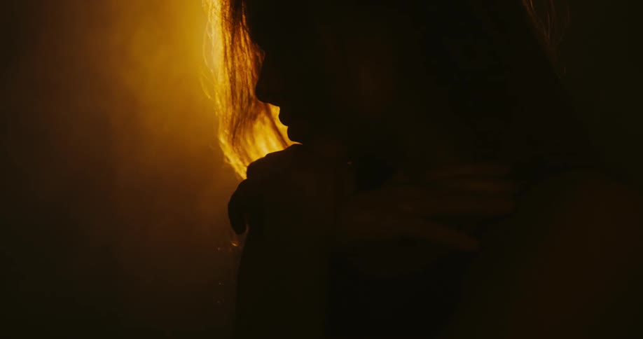 A woman rests her chin on her hands before raising her hands in the air