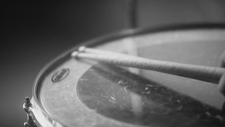A person playing with drum sticks
