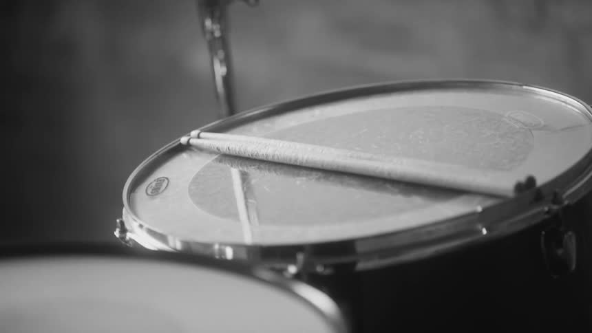 A pair of drumsticks resting atop a drum