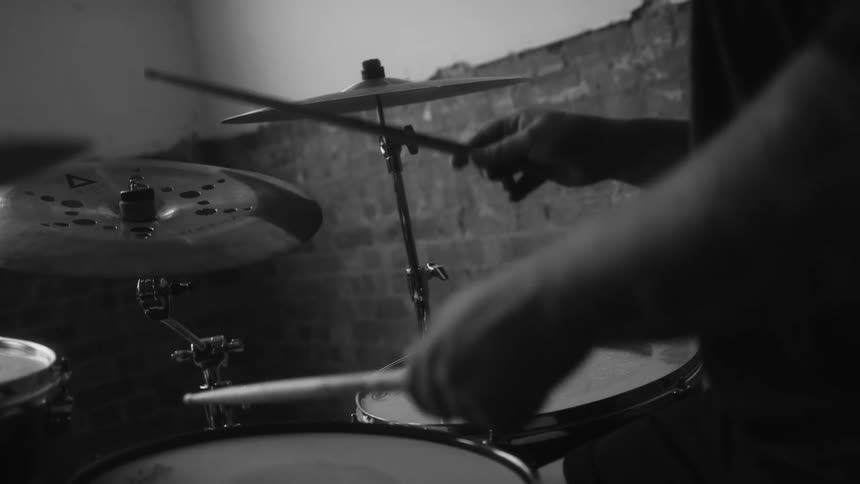 A man is playing drums at home