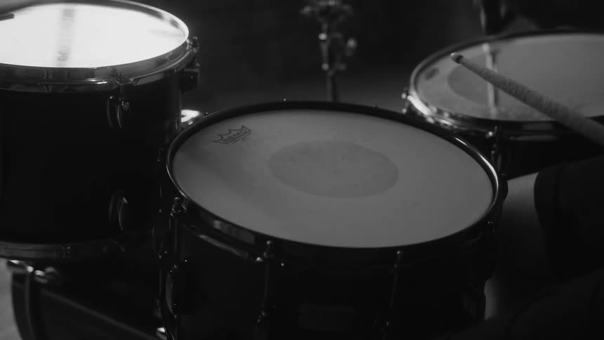 Male drummer plays drums in room