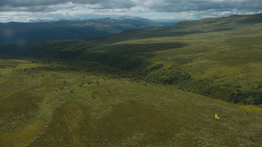 A helicopter flying over grassy hills
