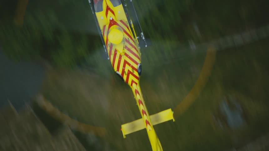 A helicopter flies over the countryside during the day