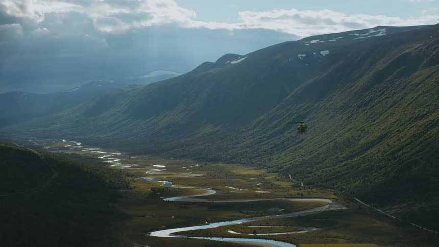 A helicopter flies through the valley