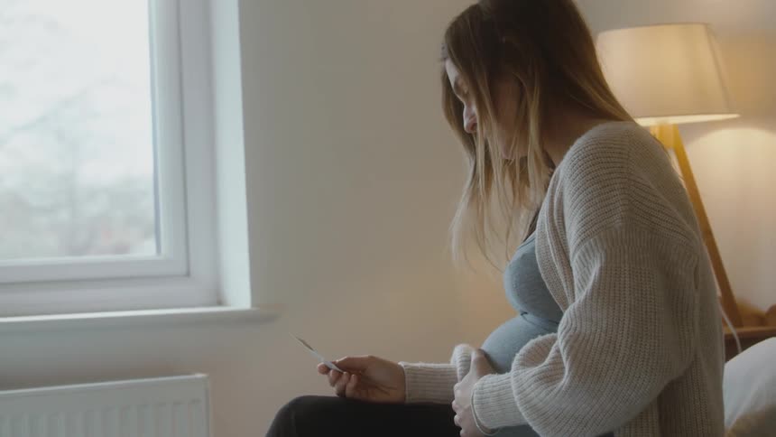 Pregnant person thinking about her birth looking at baby photo