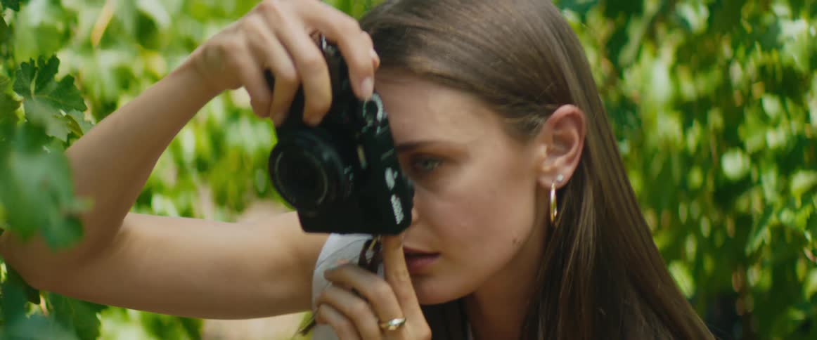 Woman taking pictures of leaves with a point and shoot camera