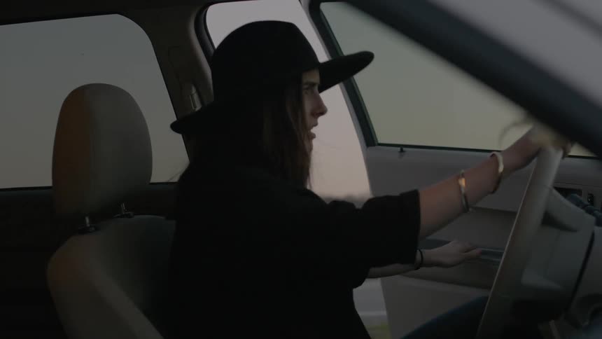 Woman getting into a car on the driver's side
