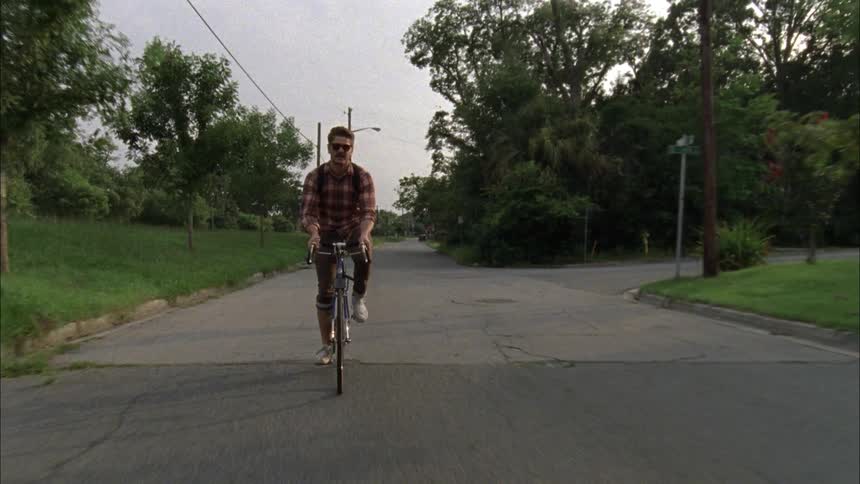 Men riding a bicycle on a city street