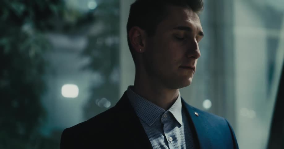 Man dressed in a suit looking angrily at his girlfriend who leaves the room right afterwards