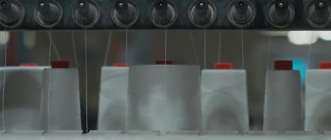 Individual strands of string hang down next to the white containers with red lids