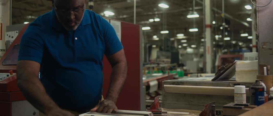Black man assembling or fixing a product at a factory