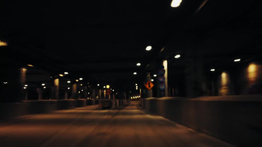 A street in a tunnel with a car driving on it