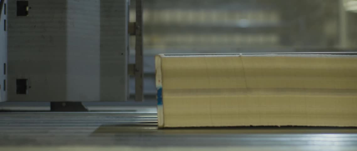 Paper moves in large stacks on a conveyor belt in a factory
