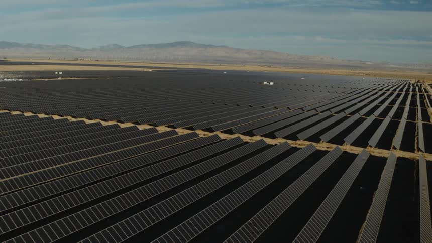 Solar panels on a solar farm with mountains in the distance