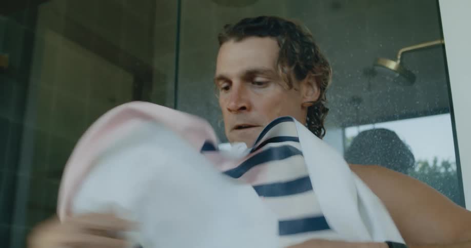 Blonde man toweling off after taking a shower