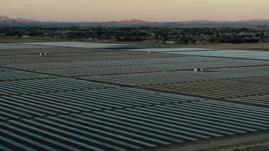 Solar panels on a solar farm with mountains in the distance