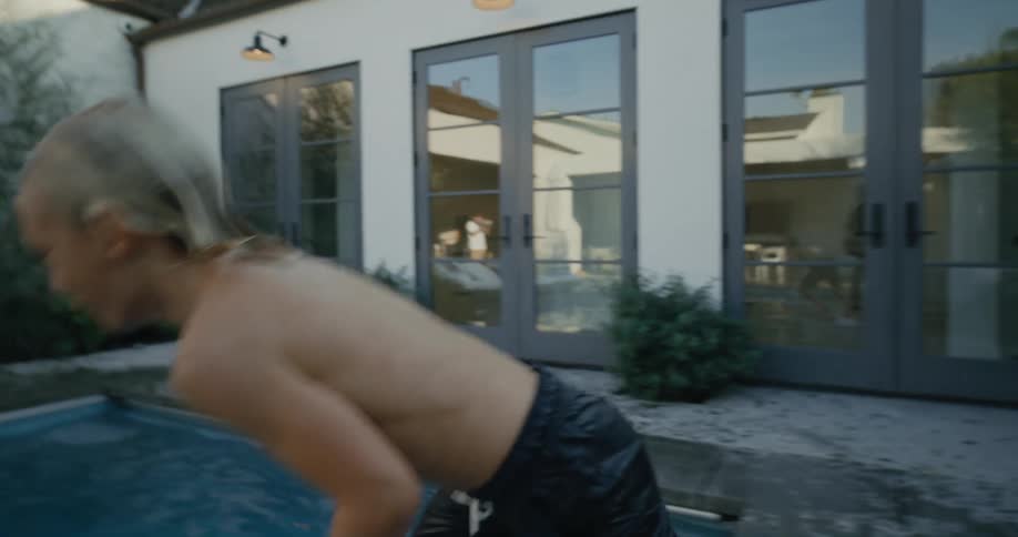 Son runs and jumps into pool joining his parents