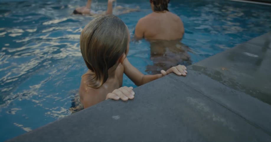 Father son and daughter swimming at the swimming pool inside their house