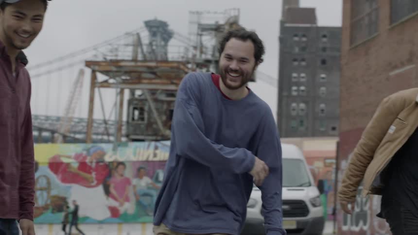 People riding their skateboards down a city street
