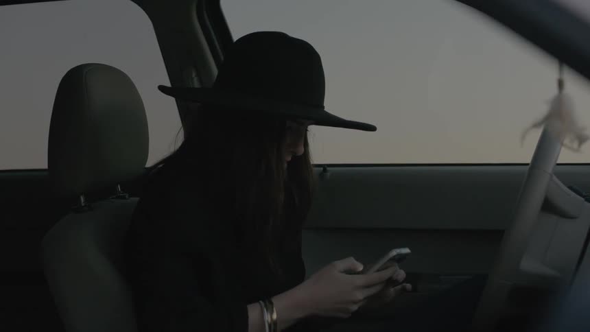 Woman sitting in car making a cell phone call