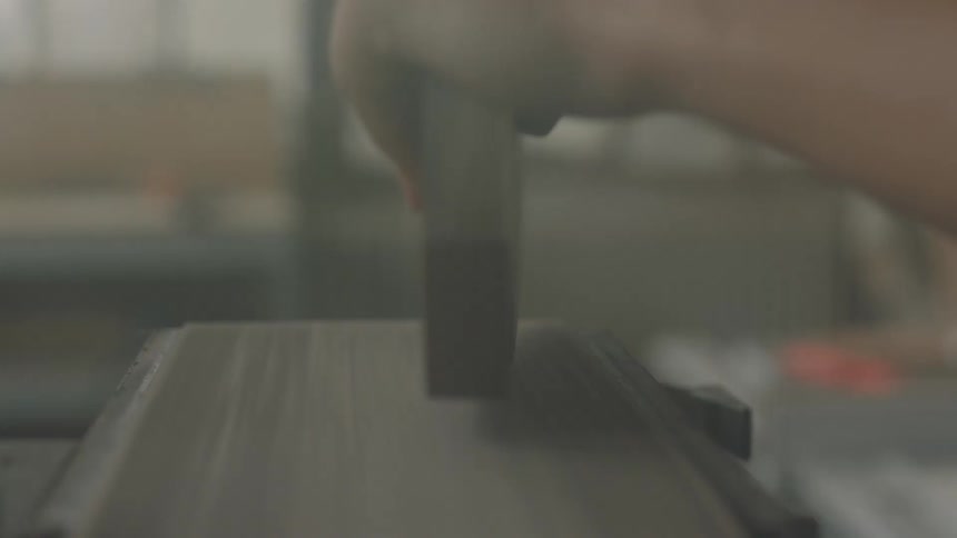 Person using a belt sander to smooth some edges
