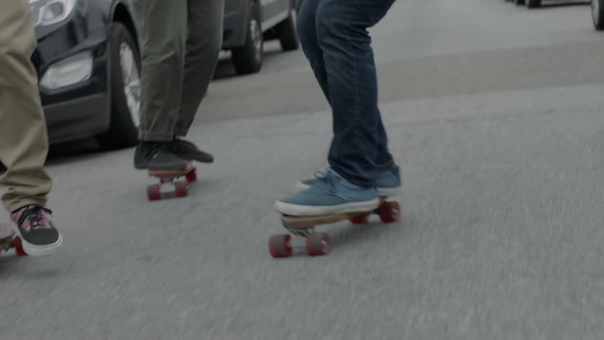 People are skateboarding together down the block