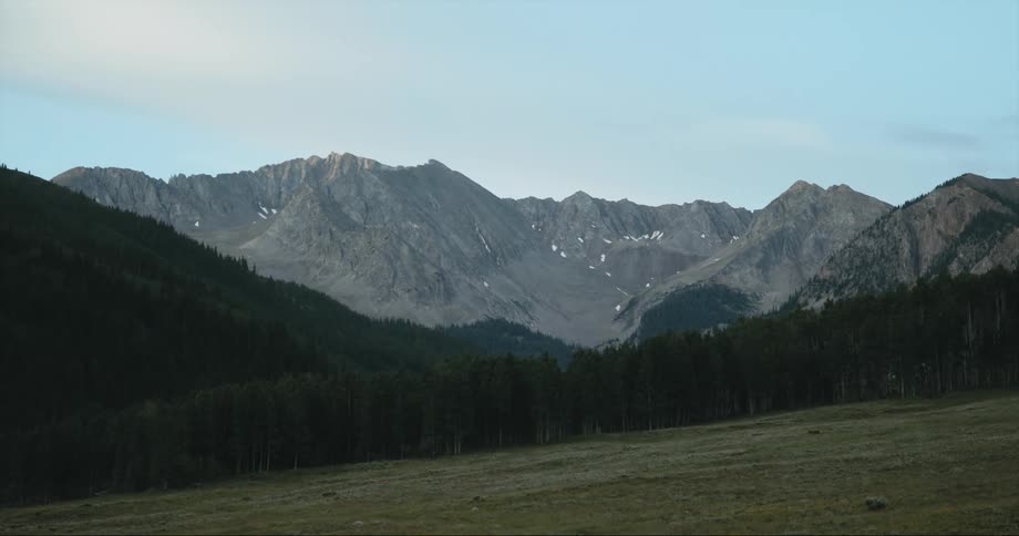 A forested mountain with a mountain ridge in the distance