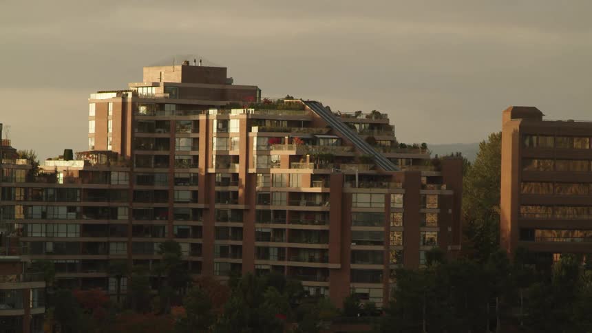 Large residential apartment building sits under a stormy sunset sky