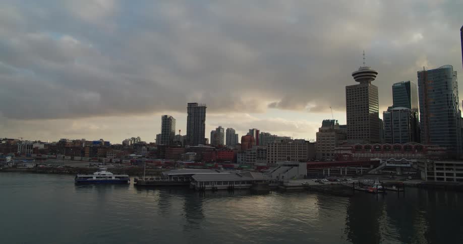 Ferry pull up to dock near city downtown on cloudy day