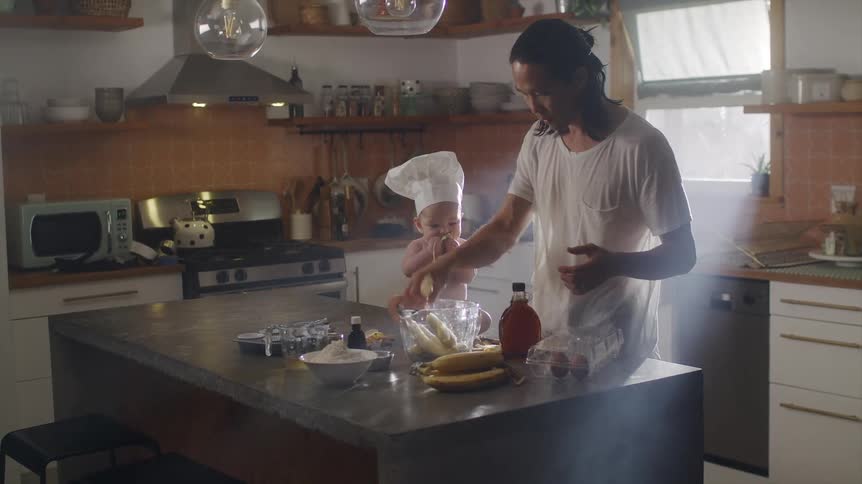 A father and son are cooking in the kitchen