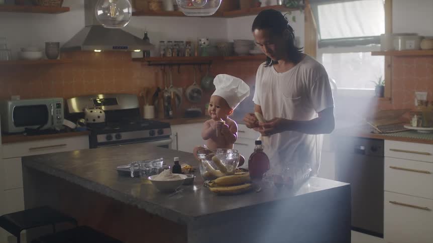 A father and son are cooking in the kitchen