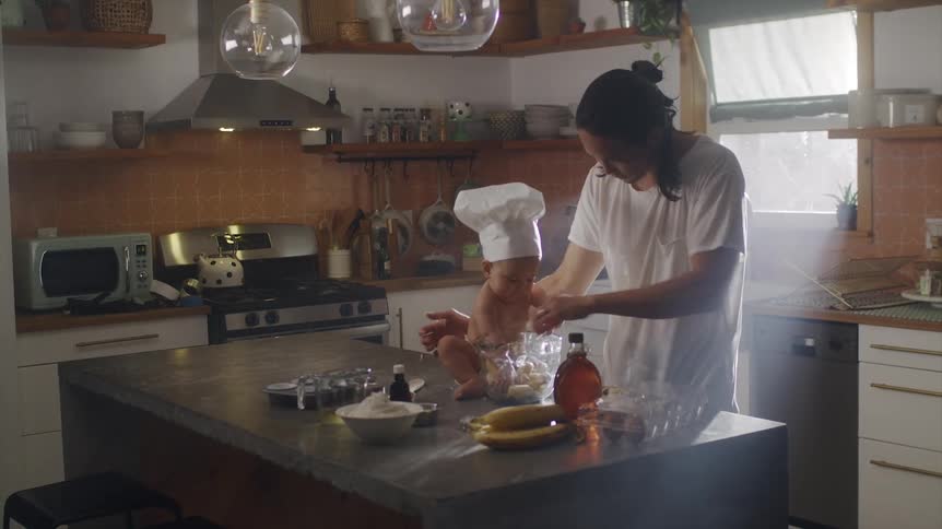 A father is cooking food with his baby