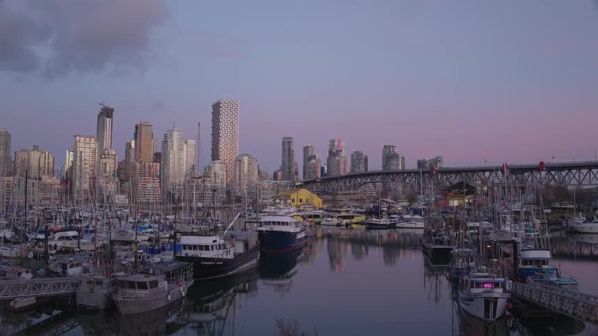 Dusk falls over a waterfront metropolis and marina
