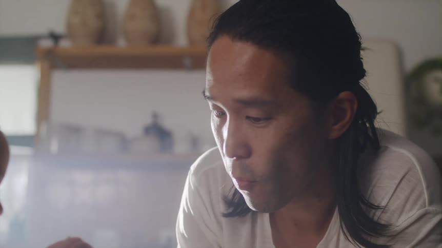 Father guides child in stirring with a spoon in the kitchen