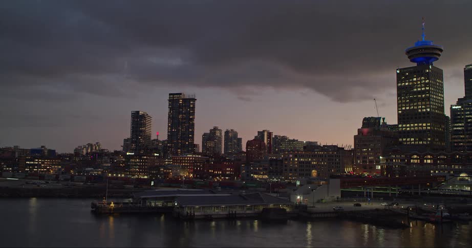 The sun sets in downtown Vancouver as boats come and go